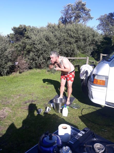 Kevin washing from a bucket of water The Outback Road-Trip - Adelaide to Uluru Happy Irish Wanderers