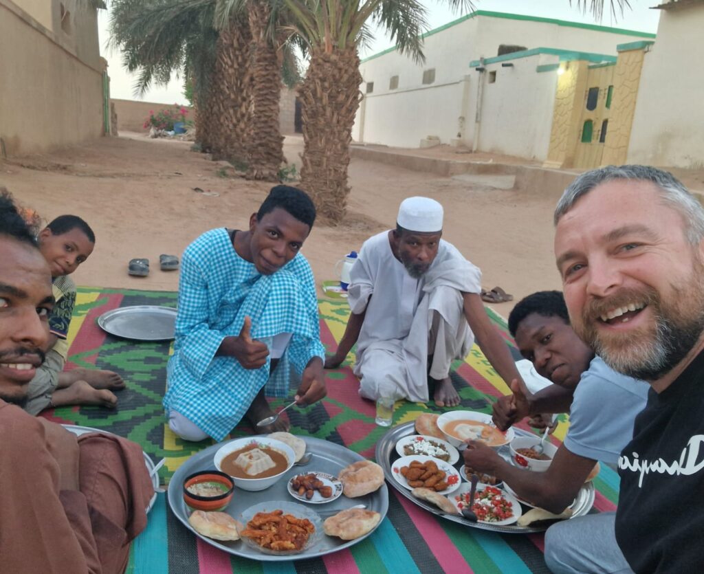 Eating local food with the family from Ahmed guesthouse in Karima Sudan, Happy Irish Wanderers