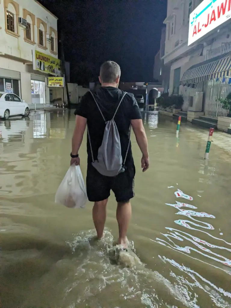 Kevin walking through floods in Sur Oman Weather - The Best Time to Visit Happy Irish Wanderers