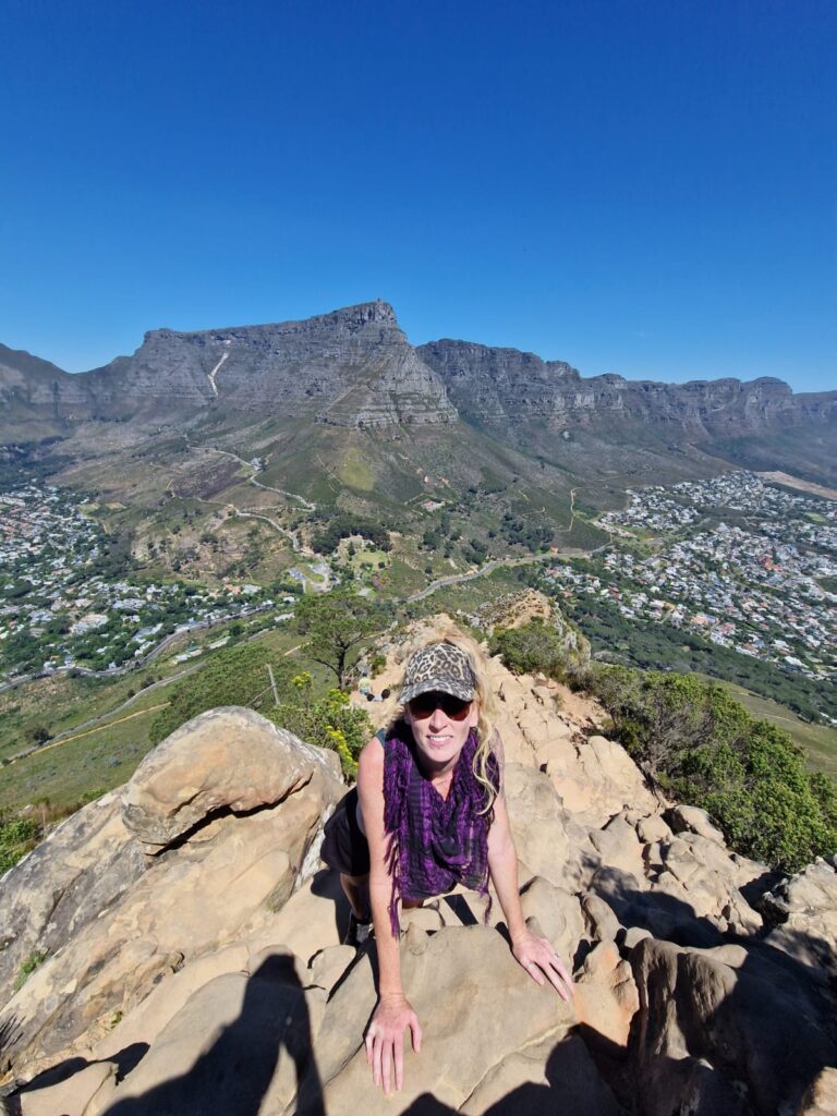 Kate from Happy Irish Wanderers climbing Lions Head with a background view of Table Mountain , Cape Town 