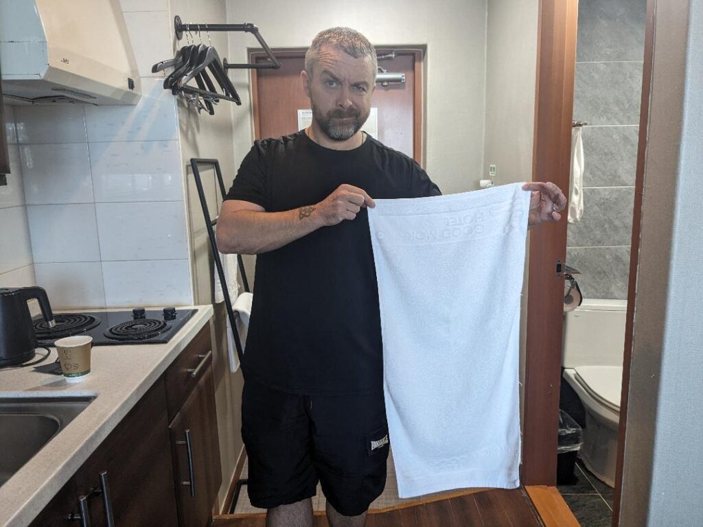 Kevin holding a small towels in South Korea travel happy Irish Wanderers