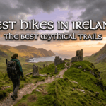 A wordpress graphic showing a female hiker with a backpack looking out over a rugged green Irish valley toward an ancient stone ruin and the sea at sunset. Text overlay reads "Best Hikes in Ireland - The Best Mythical Trails" with a checklist of highlights like "Explore Neolithic Cairns."