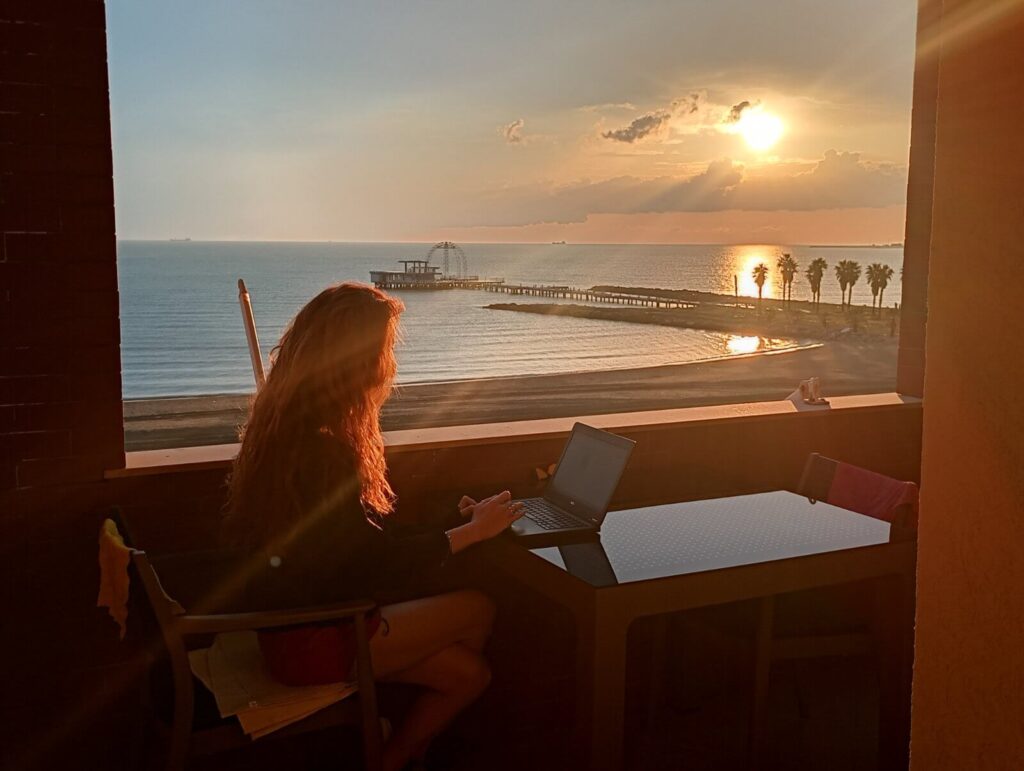 Working on laptops on beachfront apartment balcony in Durres at sunset